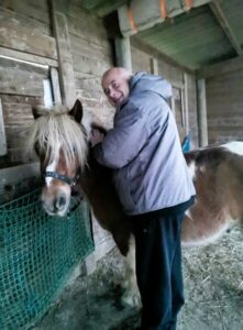 Homme calinant un poney