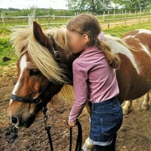 Enfant câlinant un poney d'Equi'Relation